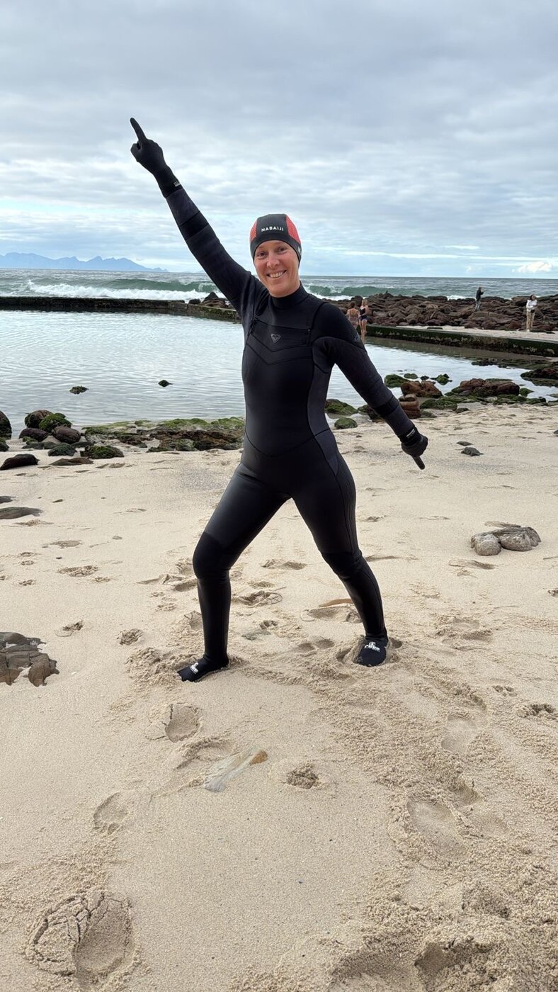 Celebrating on the beach in a wetsuit after a cold-water swim